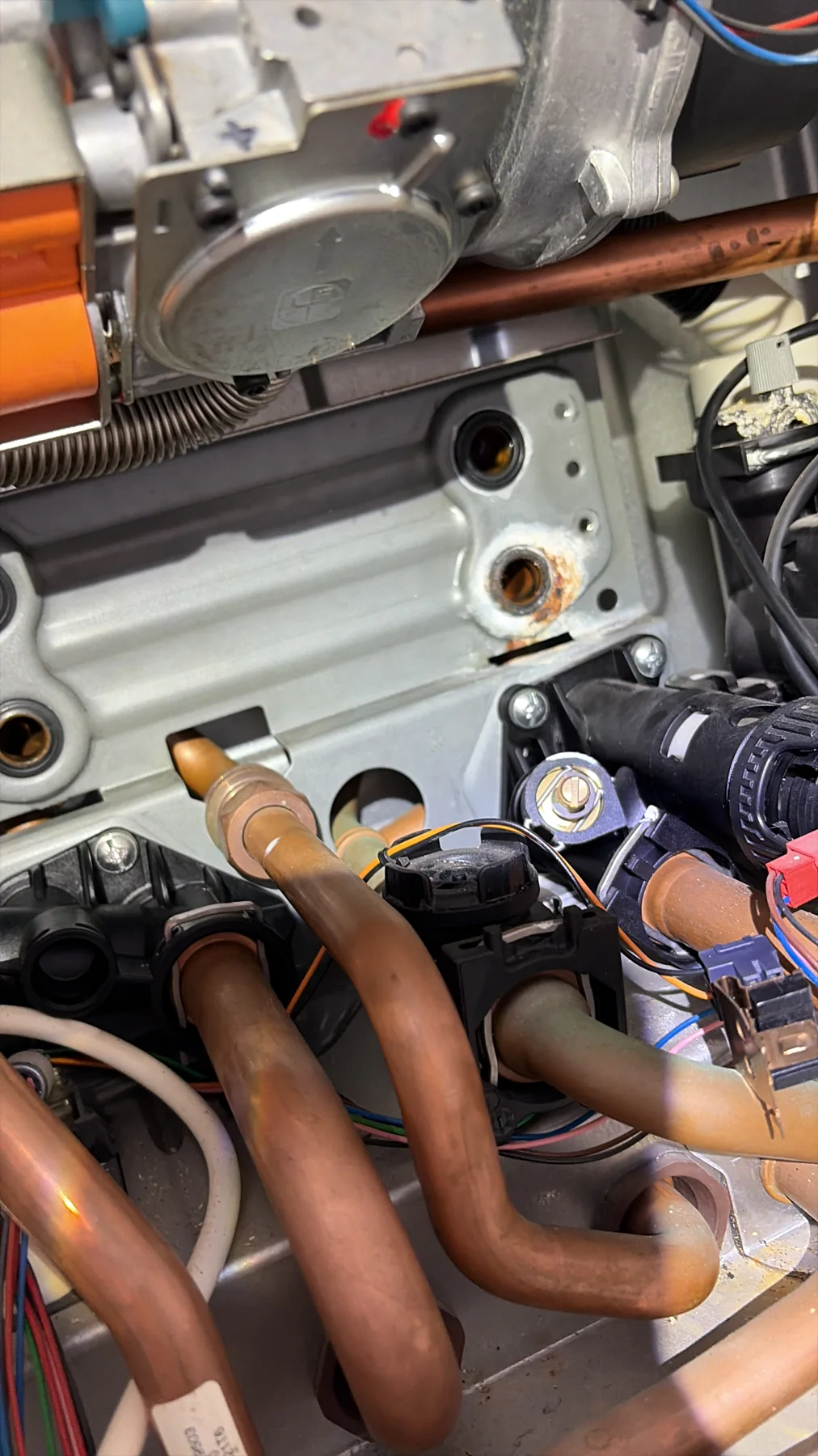 Detail van leidingen en onderdelen tijdens werkzaamheden aan een ketel.