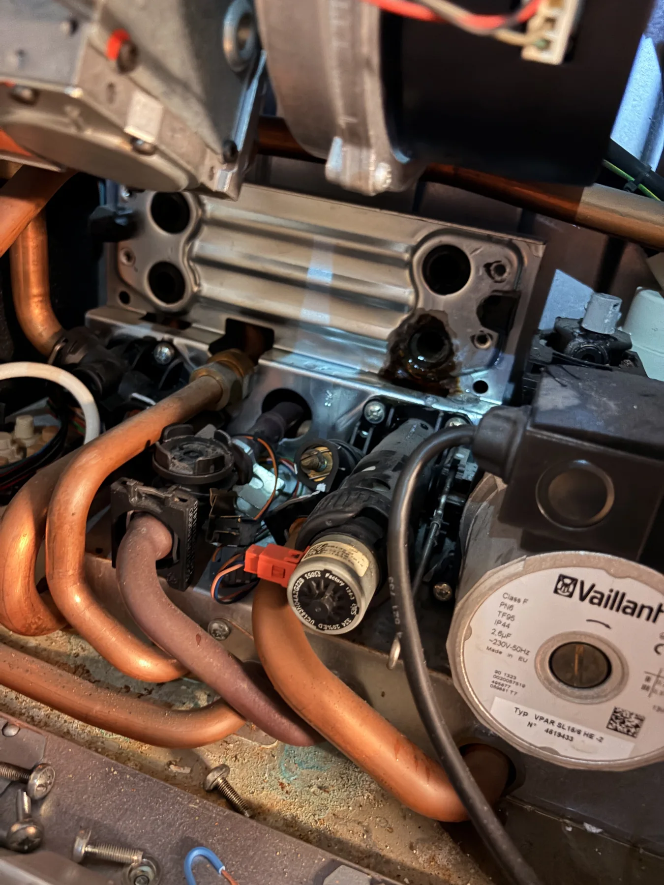 Detail van een Vaillant-pomp en de leidingen in een verwarmingsketel.